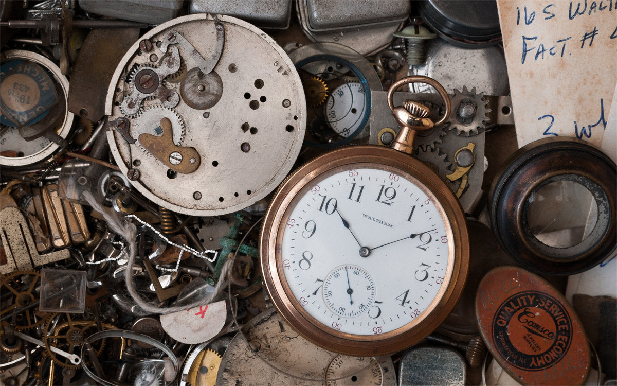 Close up of various pocket watches and watch parts.