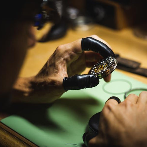 Watch movement held in the hands of a watchmaker. 