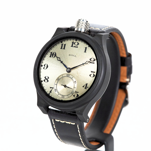 Wristwatch with black strap and beige face on a white background