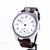 Wristwatch with brown leather strap and white dial on a white background