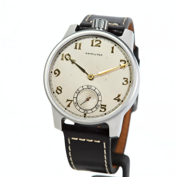 Vintage-style wristwatch with black leather strap on a white background