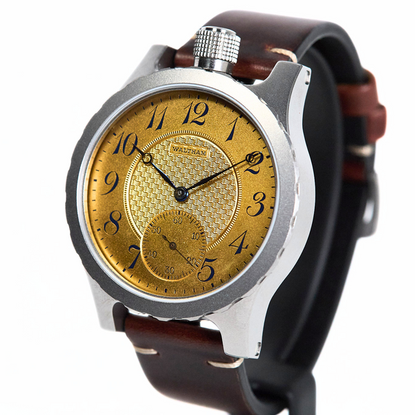 A vintage-style wristwatch with a round silver-tone case, a textured gold dial featuring black Arabic numerals and hands, and a dark brown leather strap, shown on a plain white background.