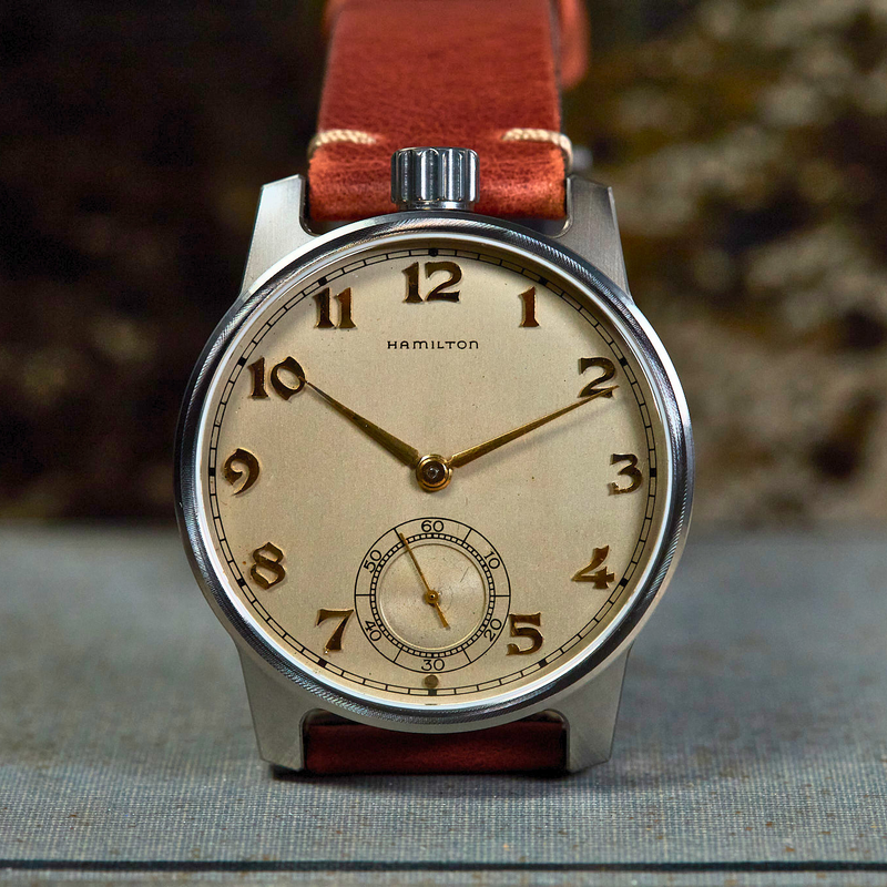 Vintage watch with a brown leather strap on a textured surface