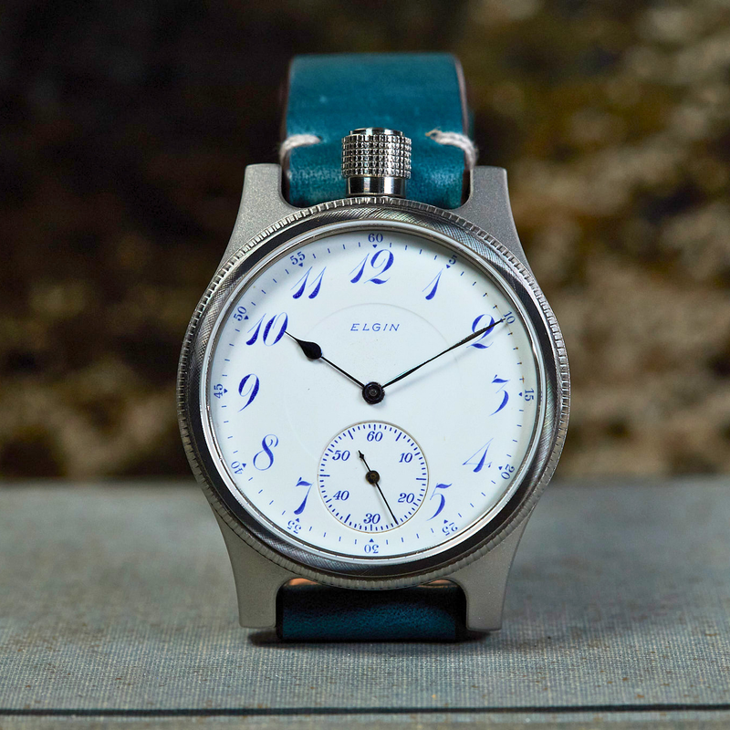 Vintage watch with blue strap on a textured surface