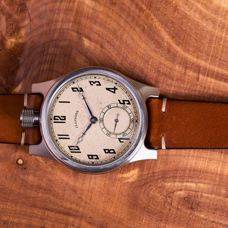 Vintage-style watch with brown leather strap on a wooden surface