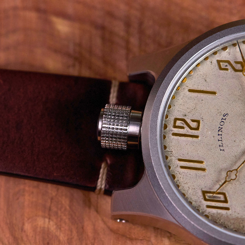 Close-up of a wristwatch with a brown leather strap on a wooden surface