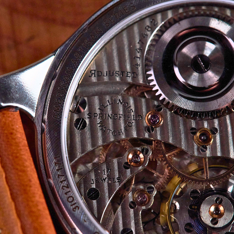 Close-up of a mechanical watch with visible gears and leather strap.