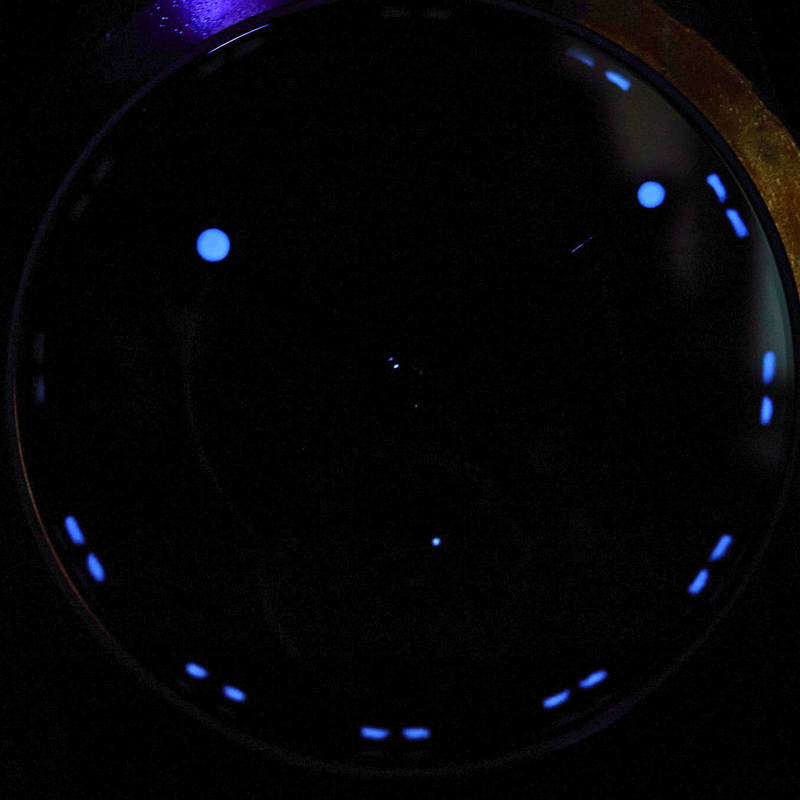Circular object with blue glowing dots on a dark background