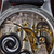 Close-up of a watch mechanism with visible branding on a wooden background