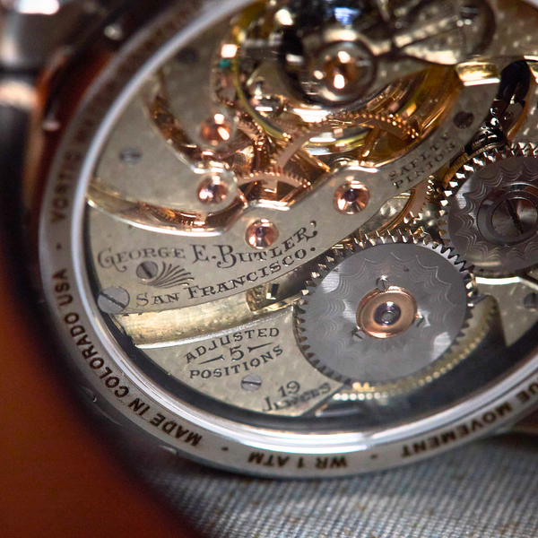 Close-up of a watch mechanism with visible branding on a textured surface