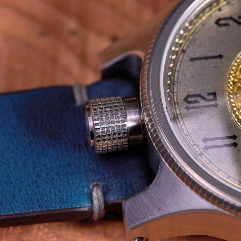 Close-up of a detailed wristwatch with a gold face on a wooden surface.