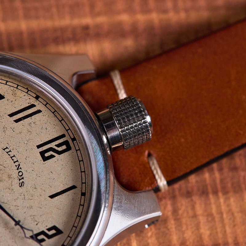 Close-up of a vintage wristwatch with a brown leather strap on a wooden surface