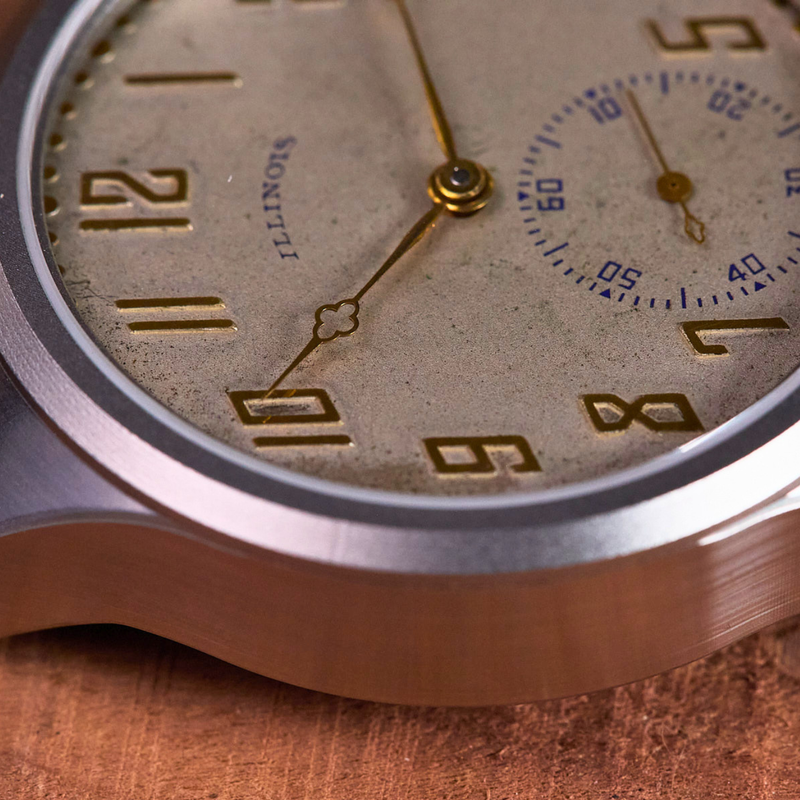 Close-up of a vintage-style watch face with metallic casing on a wooden surface