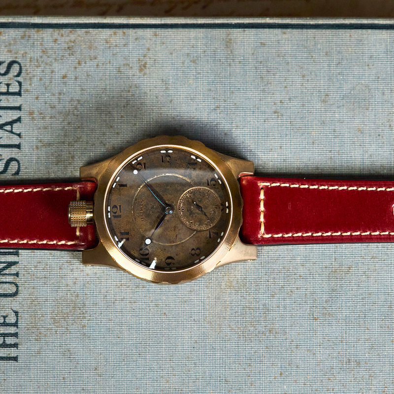Watch with red strap on an old book