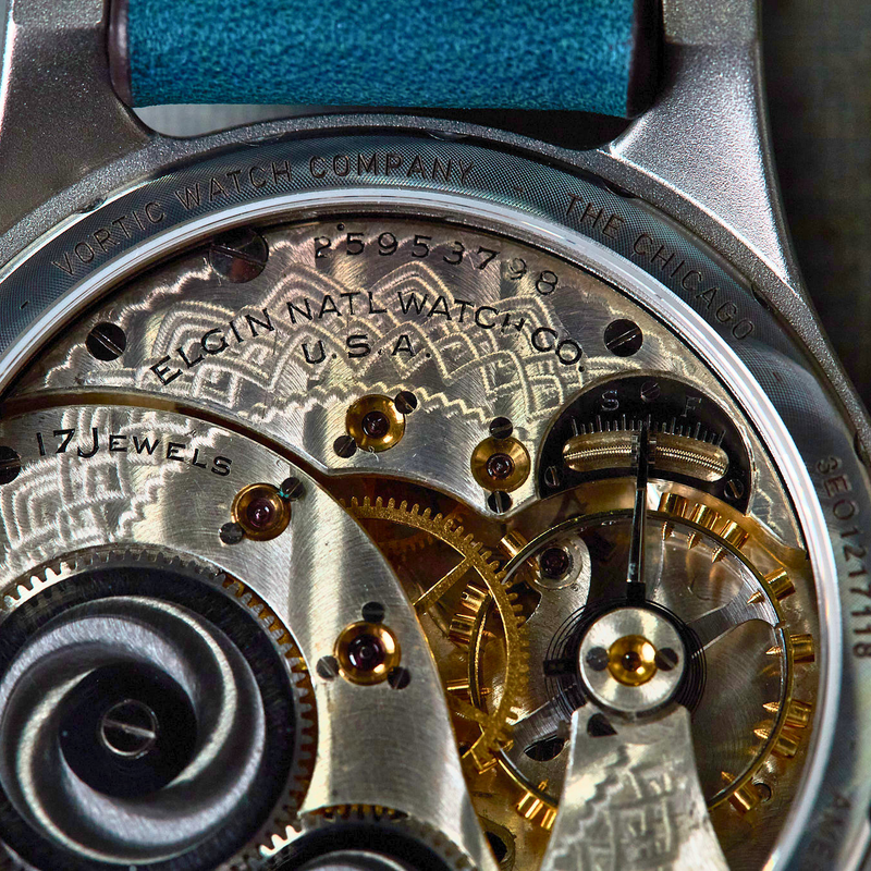 Close-up of a watch mechanism with visible branding on a textured background