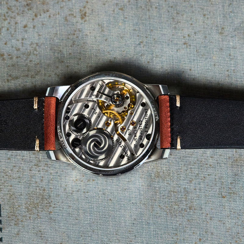 Mechanical watch with leather strap on a textured surface
