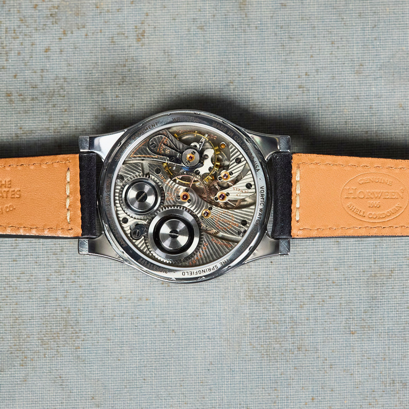 Watch with a visible mechanical movement on a textured surface