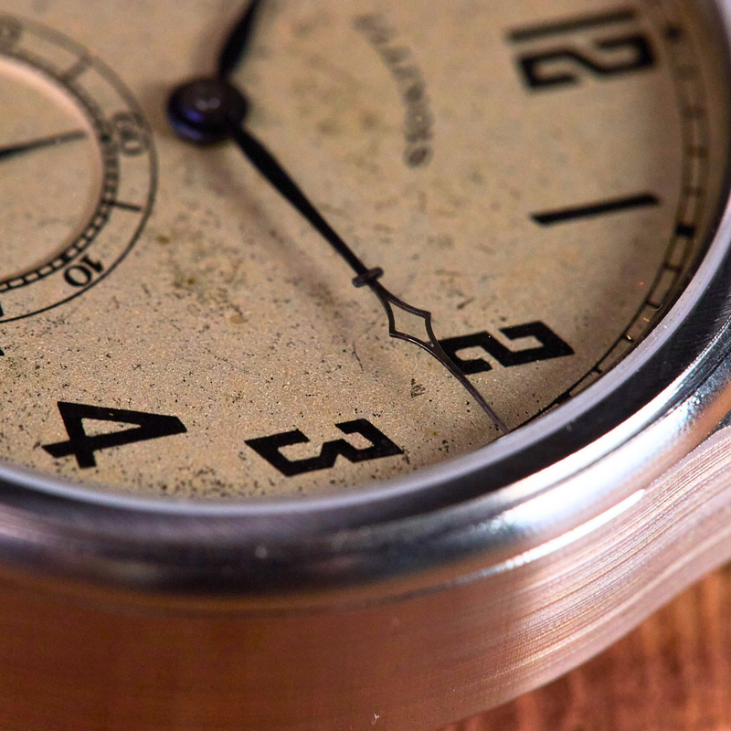 Close-up of an antique watch face with visible wear and tear.