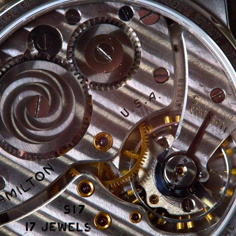Close-up of a Hamilton watch mechanism with visible branding and '17 Jewels' text.