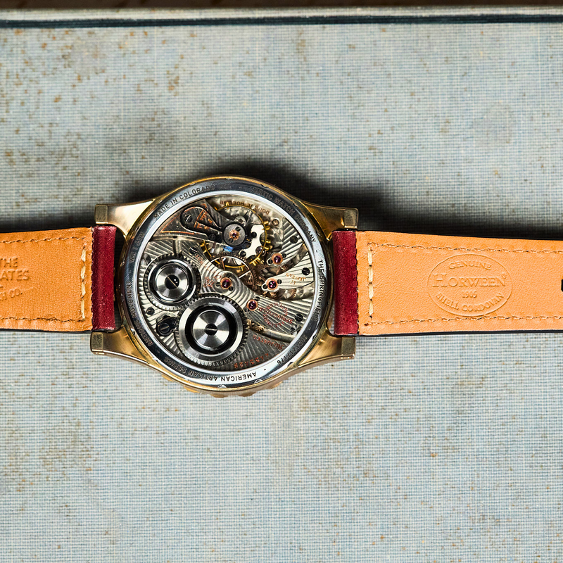 Watch with a brown leather strap on an old book