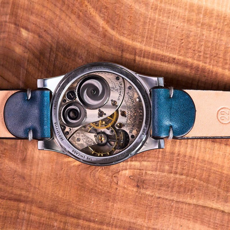 Watch with a blue strap on a wooden surface