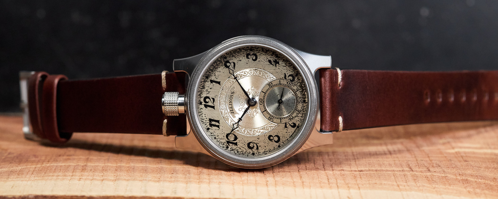 Vintage-style watch with brown leather strap on a wooden surface